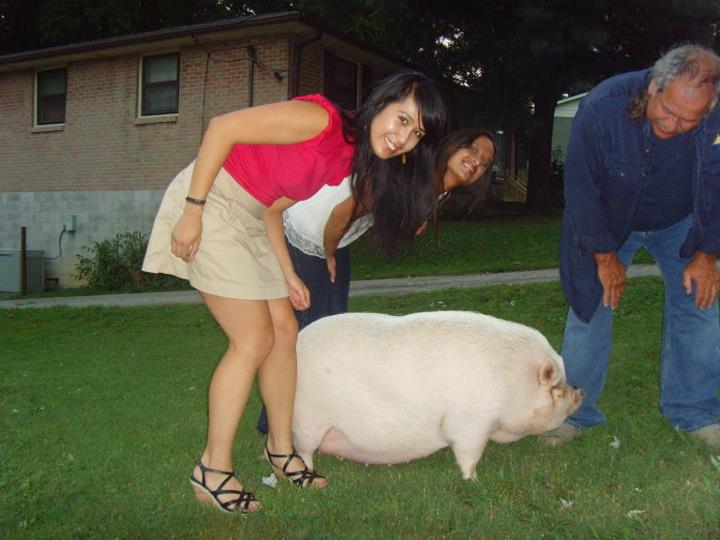 Kay standing next to a pig